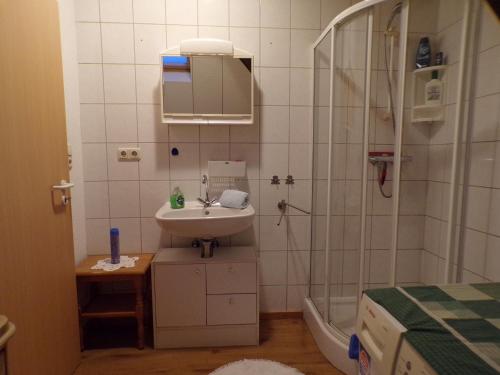 a bathroom with a sink and a shower at Ferienwohnung Hummel in Aurich