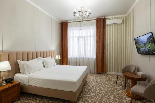 a hotel room with a bed and a chair at Boutique Hotel Tomiris in Astana