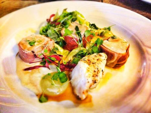 a plate of food with fish and a salad at The Hand at Llanarmon in Llanarmon Dyffryn-Ceiriog