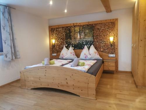 a bedroom with a wooden bed with two pillows at Schirfhof in Michaelerberg