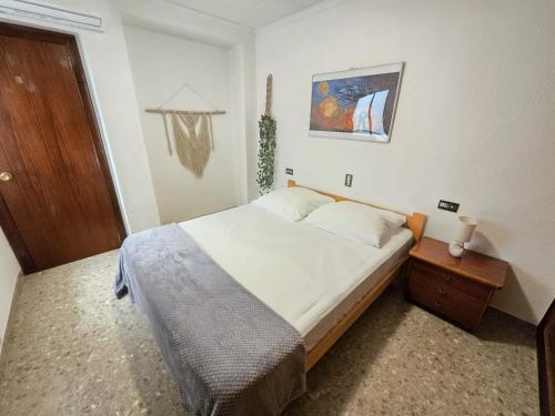 ein Schlafzimmer mit einem Bett und einer Holztür in der Unterkunft Simat Malina in Simat de Valldigna