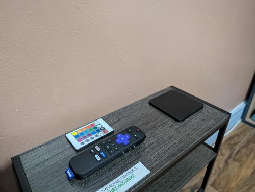 two remote controls sitting on top of a table at R3 - Cozy Small Double - City & Beach Access, WIFI, Free Parking, Bus Stop 50ft From House - Self Catering in Swansea