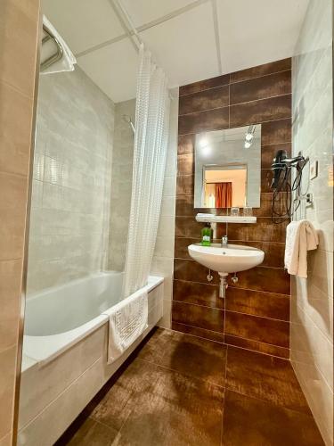 a bathroom with a tub and a sink and a bath tub at Pension Zurita in Granada
