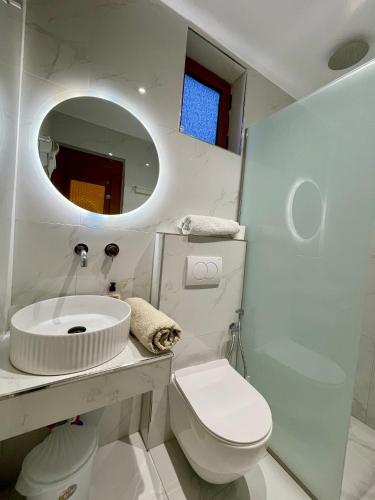 a bathroom with a sink and a toilet and a mirror at Villa Festim Ksamil in Ksamil