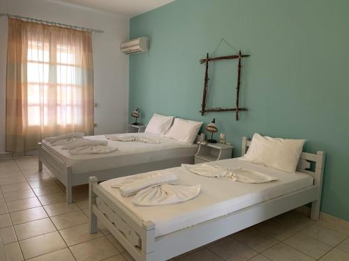 two beds sitting in a room with a window at Melissa Rooms in Koufonisia