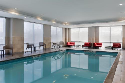 a swimming pool in a hotel with chairs and tables at avid Hotel - Toronto - Vaughan Southwest by IHG in Vaughan