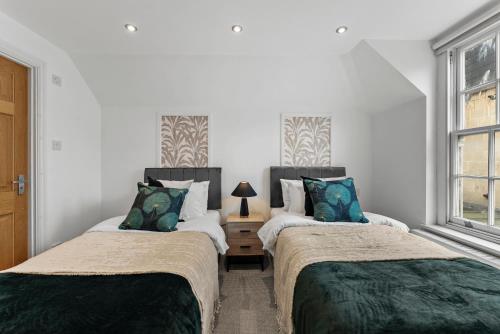 two beds in a room with white walls at Stylish Roman Bath Abode - The Gatsby in Bath