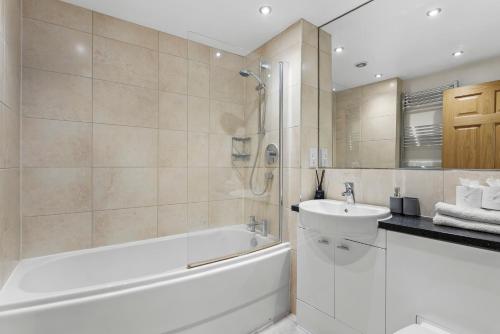 a bathroom with a bath tub and a sink at Stylish Roman Bath Abode - The Gatsby in Bath