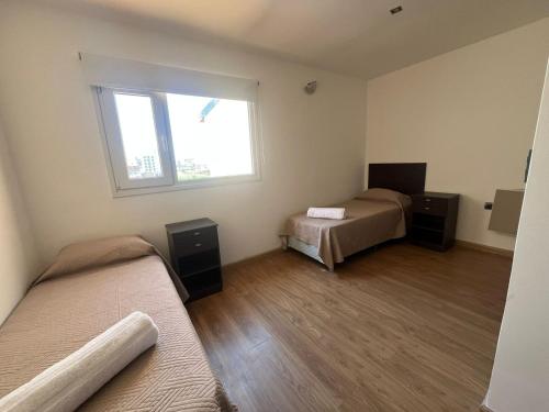 a bedroom with two beds and a window at Complejo Playa Norte in Mar de Ajó