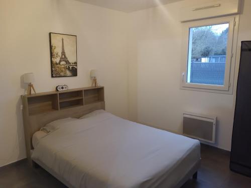 a small bedroom with a bed and a window at Maison individuelle neuve plein pied avec terrasse et jardin clos 15 minutes a pied de la plage arrivé a partir de 15h30 in Quiberville