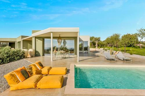 a house with a yellow couch next to a swimming pool at Fior di Noto in Noto
