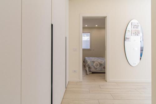 a hallway with a mirror and a room with a bed at Residenza Agave in Boario Terme