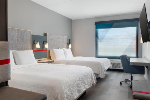 a hotel room with two beds and a window at avid Hotel - Toronto - Vaughan Southwest by IHG in Vaughan