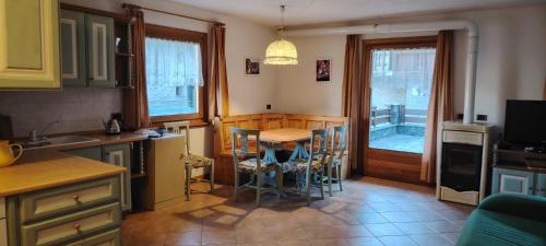 a kitchen with a table and chairs and a dining room at La Dimora della Quiete in Valdidentro