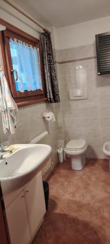 a bathroom with a white sink and a toilet at La Dimora della Quiete in Valdidentro