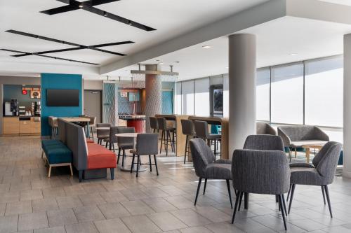 a waiting area with chairs and tables in a building at avid Hotel - Toronto - Vaughan Southwest by IHG in Vaughan
