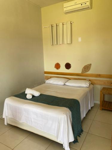a bedroom with a bed with a green blanket at Pousada Barlavento in Luis Correia