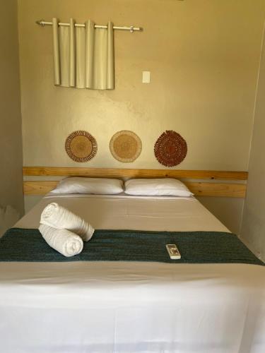 a bed in a small room with a towel on it at Pousada Barlavento in Luis Correia
