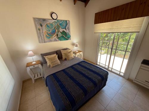 a bedroom with a bed and a large window at Duplex 4 con cochera privada y parrilla in San Clemente del Tuyú
