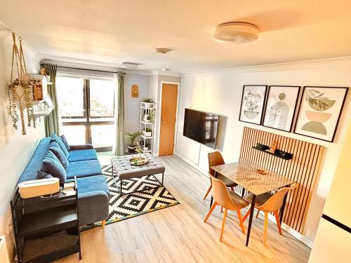 a living room with a blue couch and a table at Bond Central - City Centre Oasis in Southampton