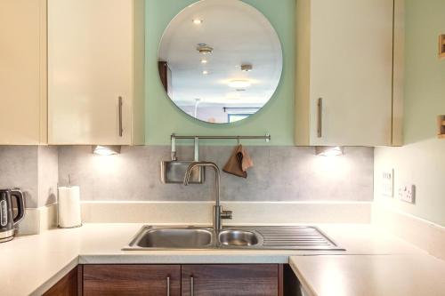 a kitchen with a sink and a mirror at Bond Central - City Centre Oasis in Southampton