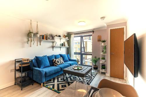 a living room with a blue couch and a table at Bond Central - City Centre Oasis in Southampton