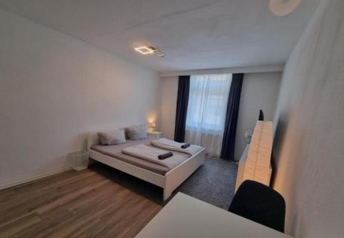 a white room with a bed and a chair in it at Süße Marie 10 in Karlsruhe