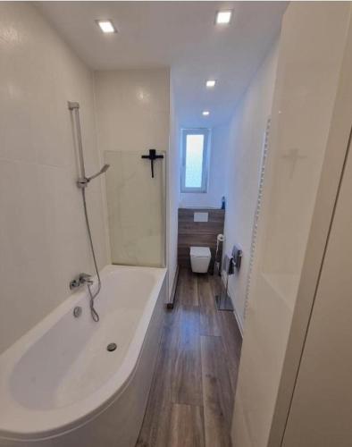 a white bathroom with a tub and a toilet at Süße Marie 10 in Karlsruhe