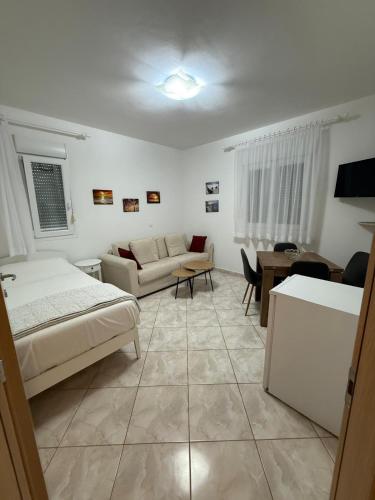 a bedroom with a bed and a living room at Appartament Tea in Šorići