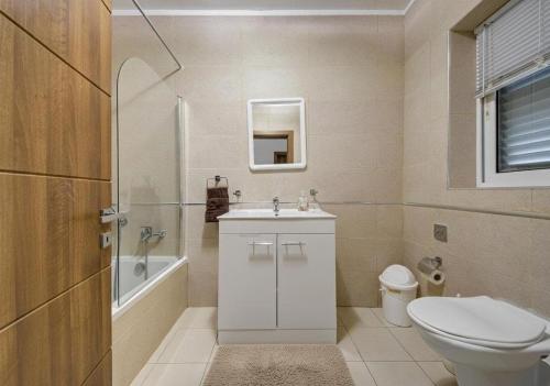 a bathroom with a toilet and a sink and a tub at Central, spacious apartment with Sea Views in St. Paul's Bay