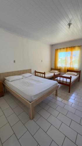 a bedroom with two beds in a room at Quartos Beira Mar ARROIO TEIXEIRA in Capão da Canoa