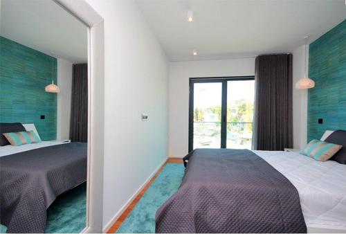 a bedroom with two beds and a large window at Astro Madeira Apartments in Funchal