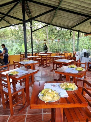a restaurant with wooden tables with plates of food on them at Posada El Remolino in Anolaima