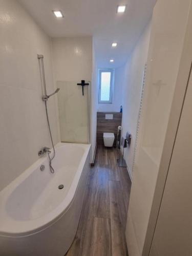 a white bathroom with a tub and a toilet at Süße Marie 11 in Karlsruhe