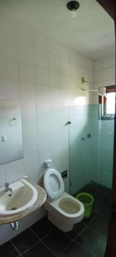 a bathroom with a toilet and a sink at Espaço Casa Cult in Serra
