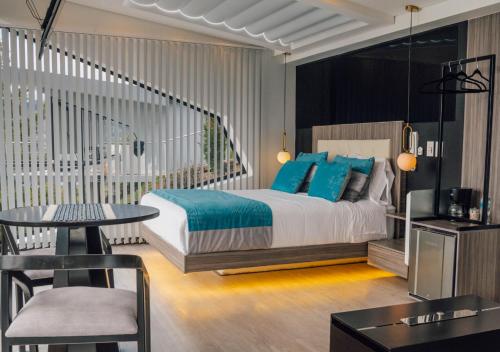 a bedroom with a bed with blue pillows and a table at Entre Islas LODGE in Aquitania
