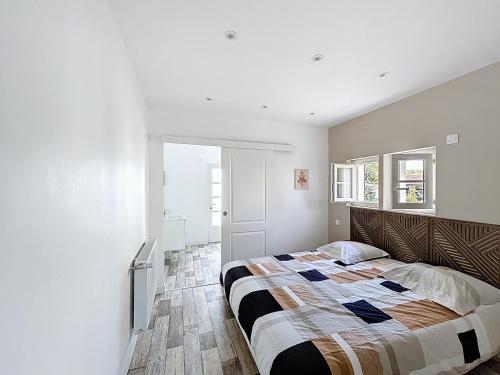 a bedroom with a bed in a white room at Cozy Alclau in Mimizan