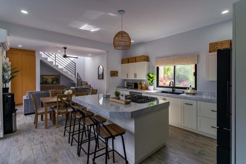 a kitchen and living room with a counter and chairs at Modern House, Rooftop Ocean Views & Private Pool in El Centenario
