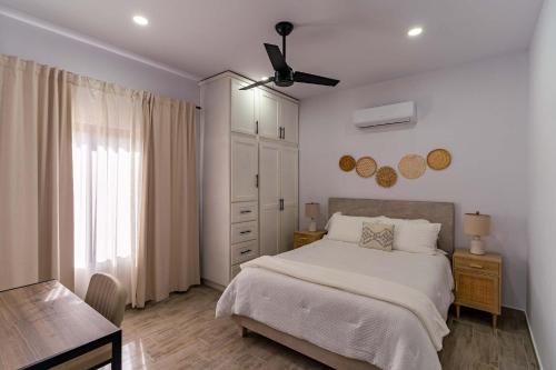 a white bedroom with a bed and a dresser at Modern House, Rooftop Ocean Views & Private Pool in El Centenario