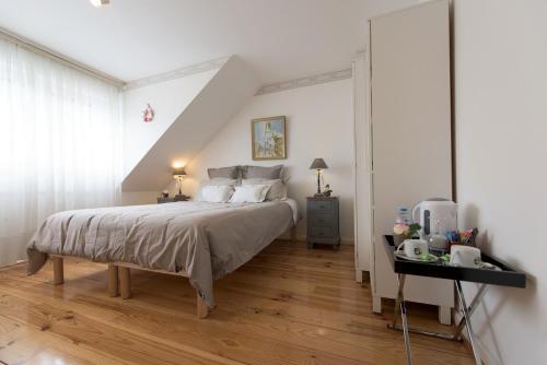 a bedroom with a bed and a table with a night stand at La Rosière de Marcq in Marcq-en-Baroeul