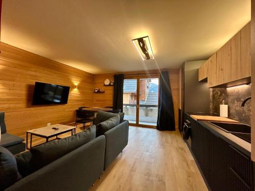 a living room with a couch and a table and a kitchen at Alpine Mood - Vue - Balcon - Parking in Uvernet
