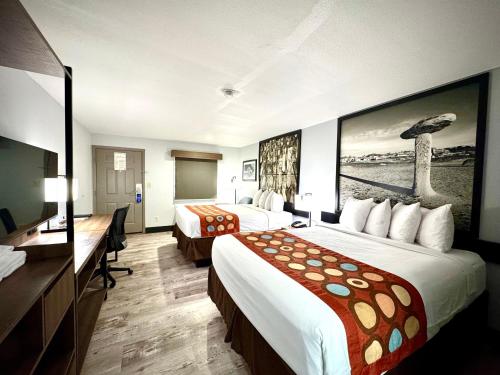 a hotel room with two beds and a desk at SureStay Plus by Best Western Cannon A.F.B. in Clovis