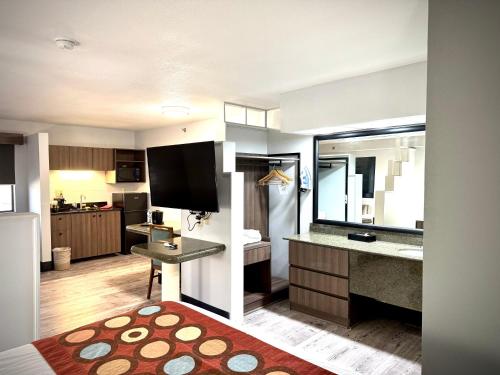 a living room with a large kitchen with a television at SureStay Plus by Best Western Cannon A.F.B. in Clovis