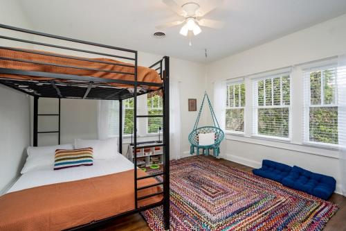 a bedroom with two bunk beds and a swing at Colorful waterside home in Bradenton