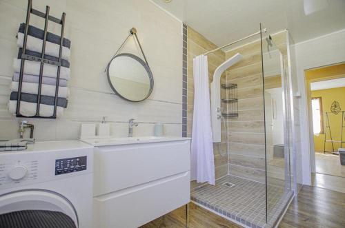 a bathroom with a shower and a sink and a washing machine at Maison des 3 lacs in Chavanges