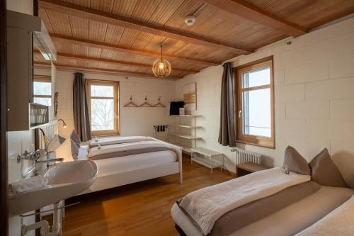 a bedroom with three beds and a sink and a sink at BnB SchlafSchloss in Sumiswald