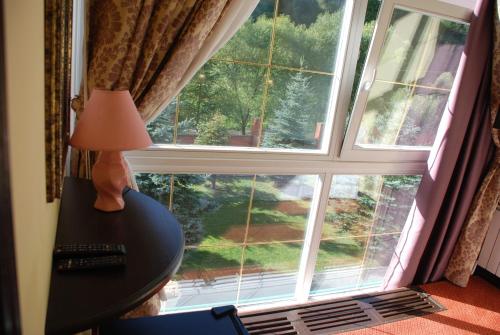 a table with a lamp and a large window at Chalet Zolota Pidkova&River 1 in Slavske