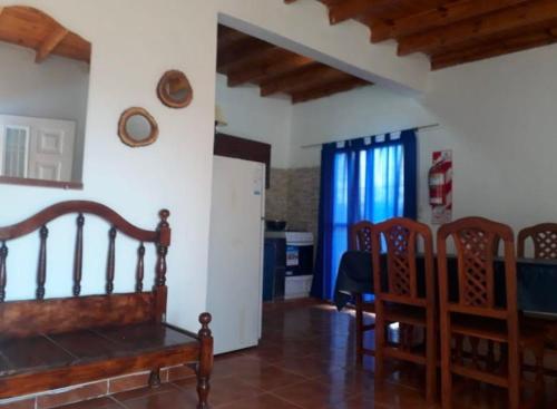 a living room with a wooden bench and a kitchen at cabaña huguito y vane in Tinogasta