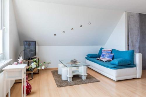 a living room with a blue couch and a table at Ferienwohnung Sterntaler in Goldbeck