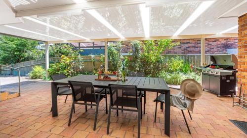 a patio with a table and chairs and a stove at La Playa in Myola